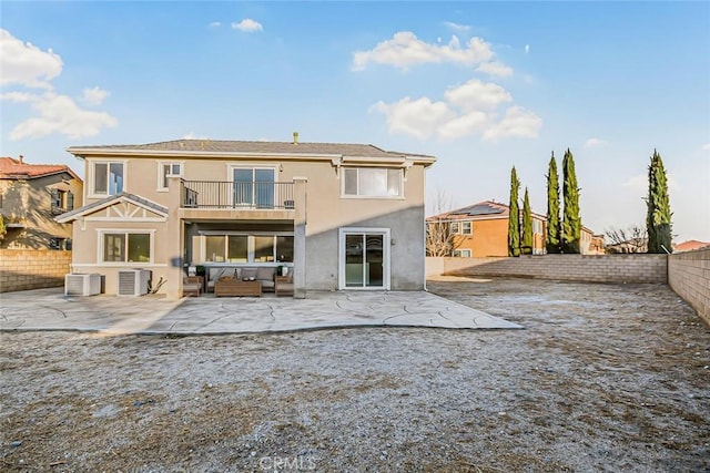 rear view of house featuring a patio area, a balcony, and central air condition unit