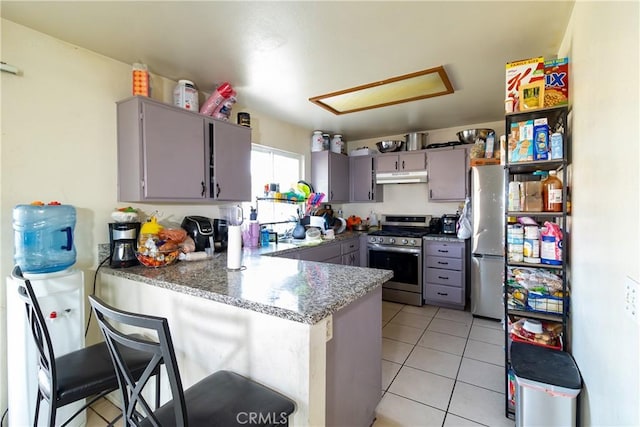 kitchen featuring a breakfast bar, gray cabinetry, stainless steel appliances, light tile patterned flooring, and kitchen peninsula