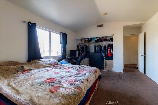 bedroom featuring lofted ceiling, dark carpet, and a closet