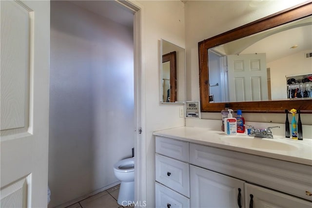 bathroom with tile patterned flooring, vanity, and toilet