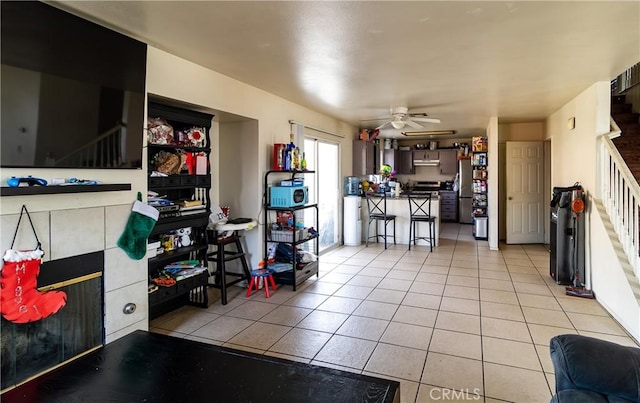 kitchen with light tile patterned flooring, ceiling fan, and stainless steel fridge