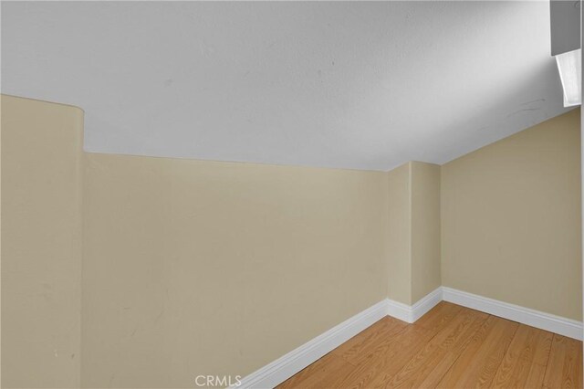 empty room with lofted ceiling and light wood-type flooring