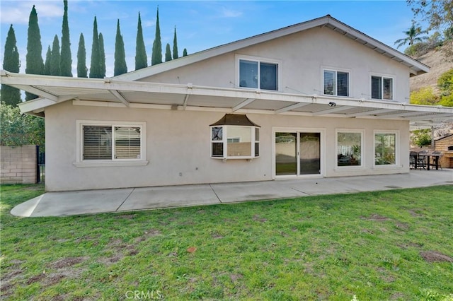 rear view of property with a yard and a patio area