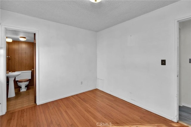 empty room featuring light hardwood / wood-style flooring and a textured ceiling