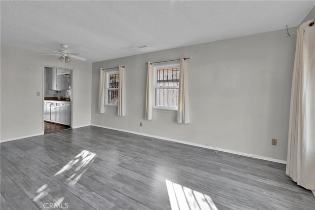 interior space featuring ceiling fan, dark hardwood / wood-style flooring, and a textured ceiling