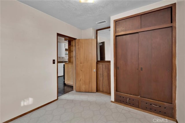 unfurnished bedroom with a closet and a textured ceiling