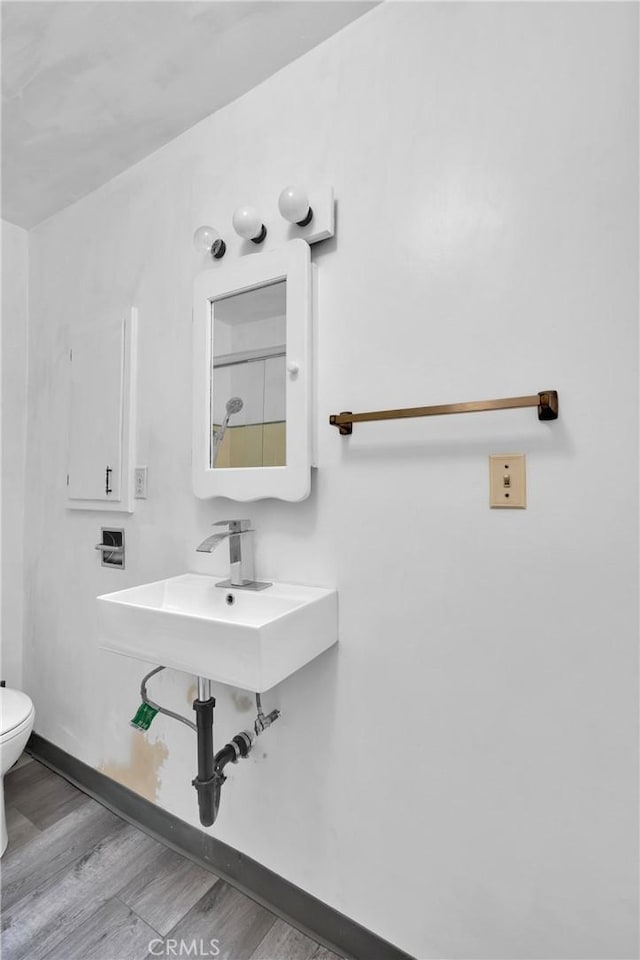 bathroom featuring wood-type flooring, sink, and toilet