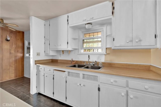 kitchen featuring white cabinetry, sink, dark tile patterned floors, and ceiling fan