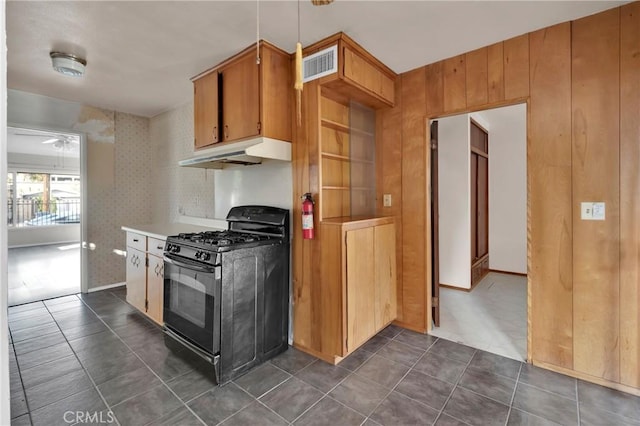 kitchen with black gas range and dark tile patterned floors