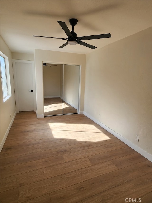 unfurnished bedroom with ceiling fan, hardwood / wood-style floors, and a closet