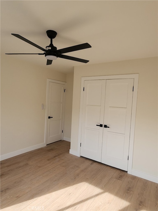 unfurnished bedroom featuring ceiling fan, light hardwood / wood-style floors, and a closet