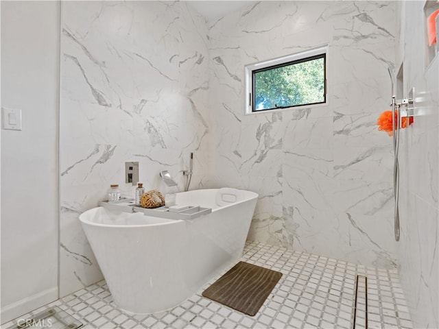 full bath featuring a freestanding tub and a marble finish shower