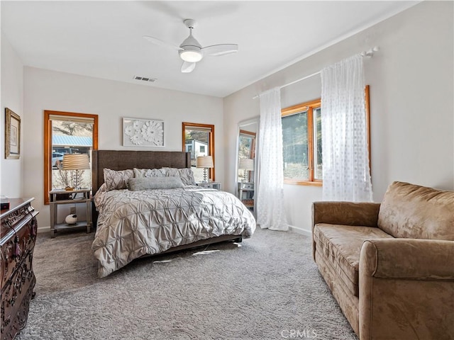 carpeted bedroom with a ceiling fan, visible vents, and baseboards