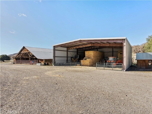 view of pole building featuring driveway and a detached carport