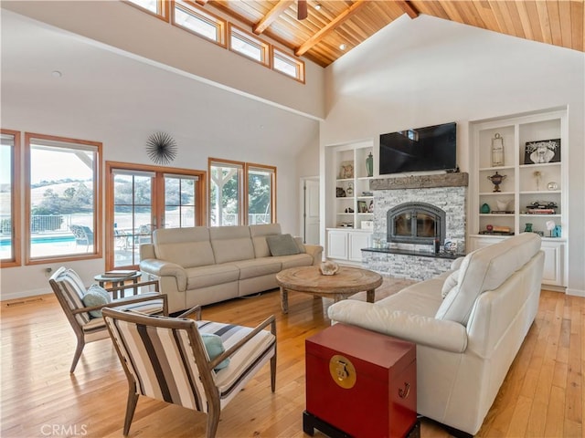 living room with built in shelves, light wood-style flooring, a fireplace, wood ceiling, and french doors