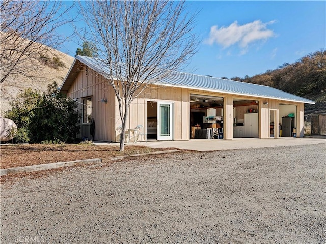 rear view of house featuring metal roof and board and batten siding