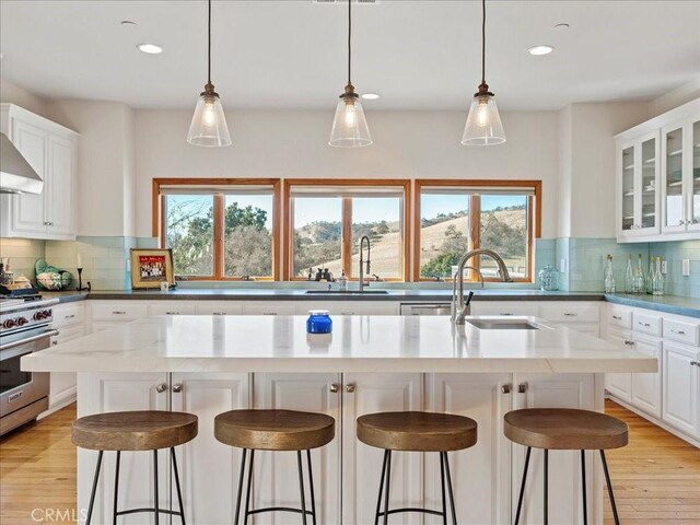 kitchen featuring stainless steel range, a breakfast bar area, a sink, and a center island with sink