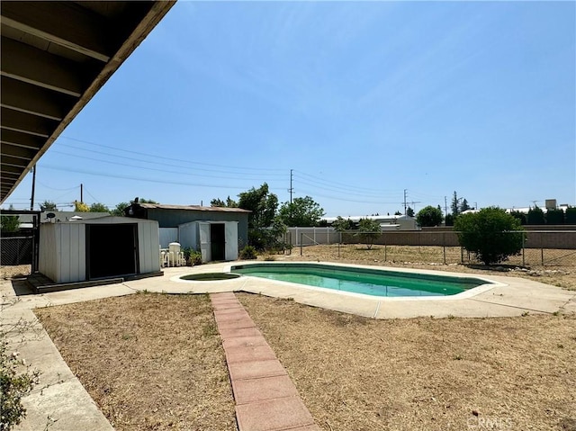 view of pool featuring an in ground hot tub and a shed