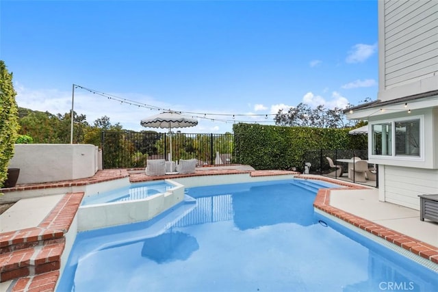 view of swimming pool featuring an in ground hot tub and a patio