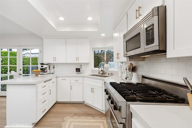 kitchen featuring white cabinetry, appliances with stainless steel finishes, sink, and kitchen peninsula