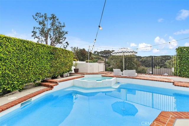 view of swimming pool with an in ground hot tub