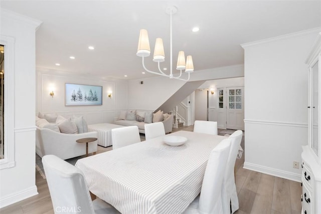 dining area with crown molding, a chandelier, and light hardwood / wood-style floors