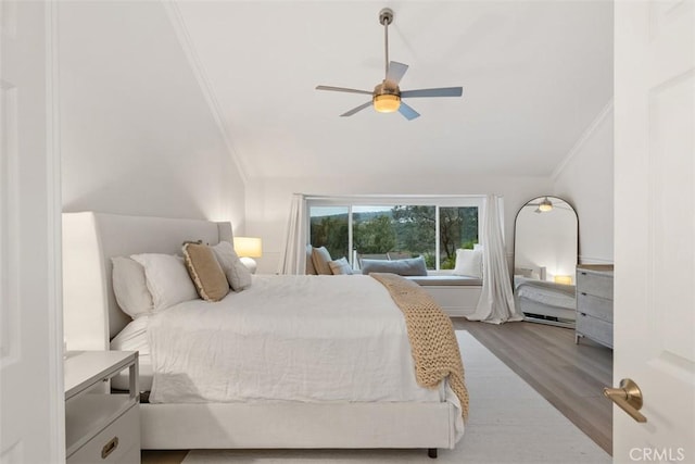 bedroom with vaulted ceiling, ornamental molding, light hardwood / wood-style floors, and ceiling fan