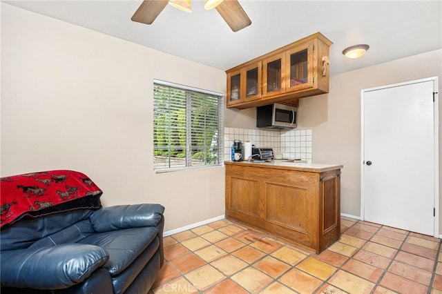 kitchen featuring light tile patterned floors, ceiling fan, and decorative backsplash