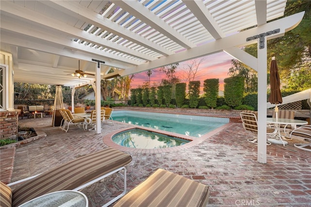 pool at dusk featuring an in ground hot tub, a pergola, and a patio area