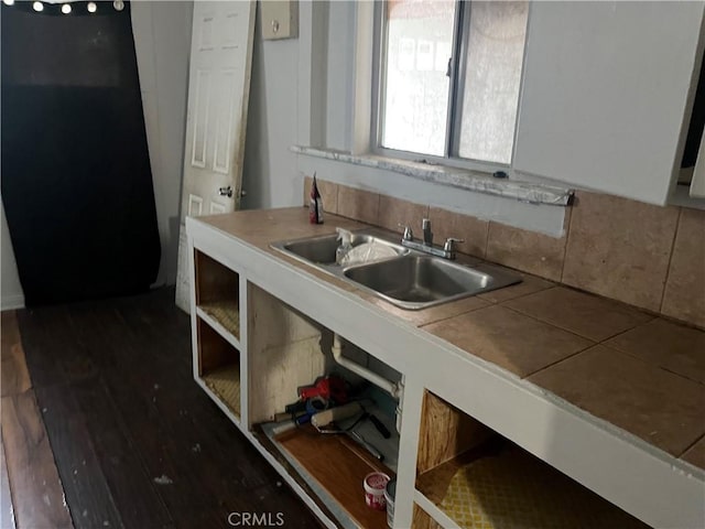 kitchen featuring black fridge, sink, tile countertops, and dark wood-type flooring