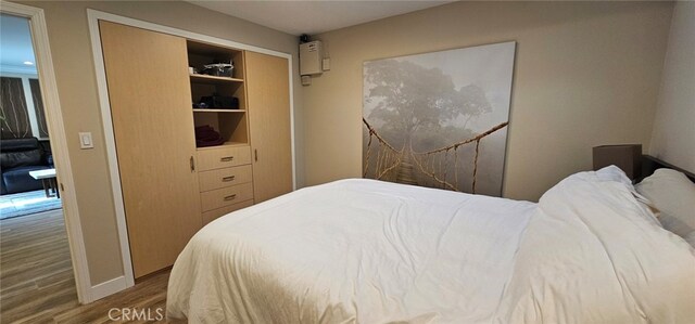 bedroom with wood-type flooring and a closet