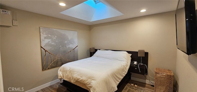 bedroom featuring dark wood-type flooring and a skylight