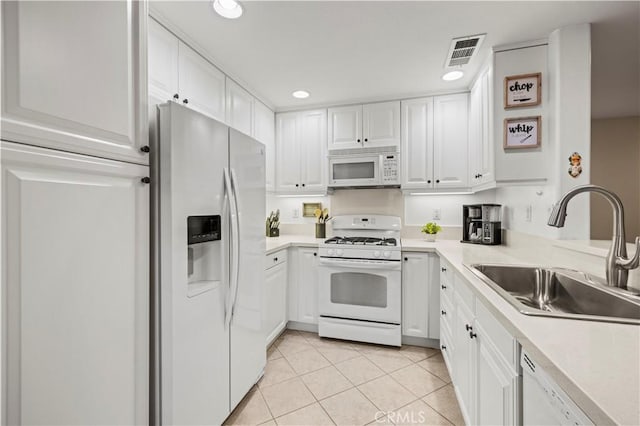 kitchen with white cabinetry, white appliances, light tile patterned flooring, and sink