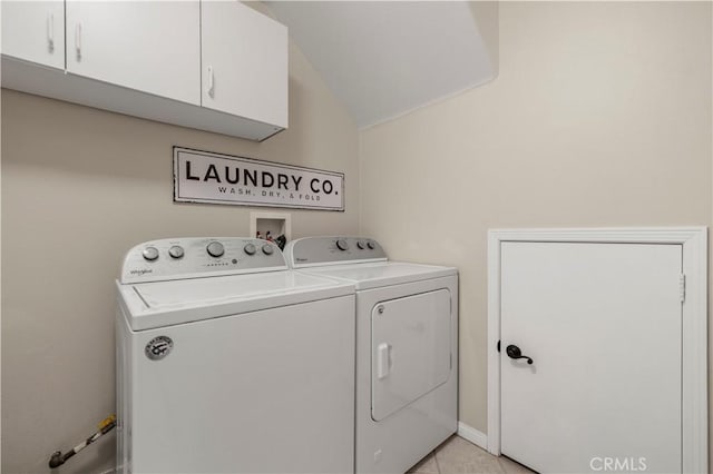 washroom with separate washer and dryer, light tile patterned flooring, and cabinet space