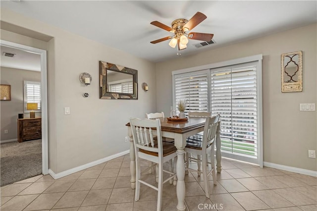 dining room with light tile patterned floors, ceiling fan, visible vents, and baseboards