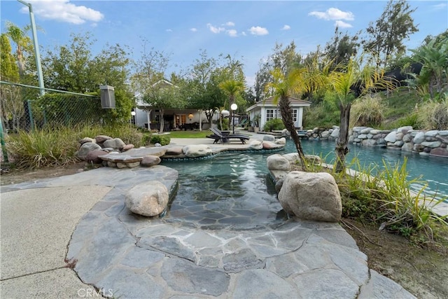 view of swimming pool featuring a patio and an outbuilding