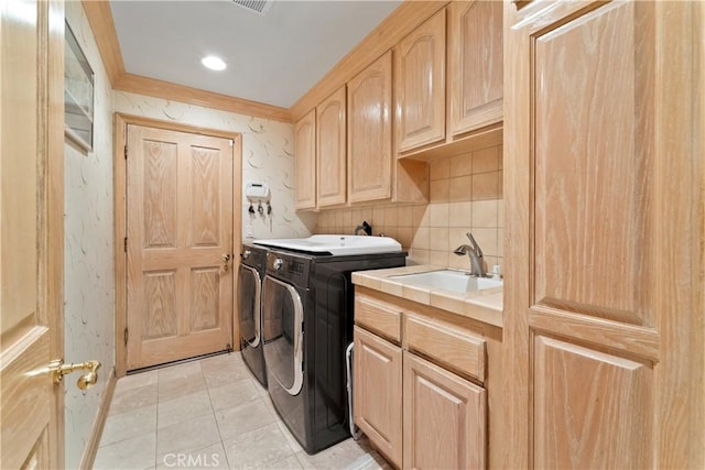 laundry area featuring sink, light tile patterned floors, washing machine and dryer, cabinets, and ornamental molding