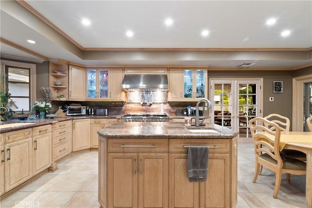 6011 Paseo La Vis, Woodland Hills, CA 91367 - kitchen with wall chimney range hood, a kitchen island with sink, light brown cabinetry, light tile patterned floors, and a sink