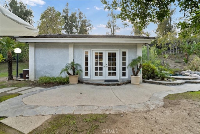 view of exterior entry with cooling unit, a patio area, and french doors