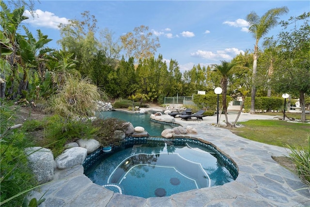 view of pool with an in ground hot tub and a patio