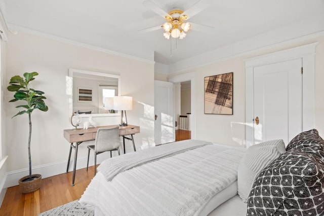 bedroom featuring hardwood / wood-style flooring, ceiling fan, and ornamental molding