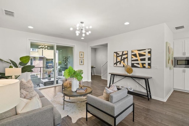 living room featuring an inviting chandelier and dark wood-type flooring