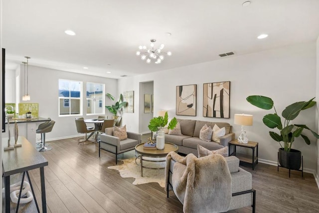 living room with dark wood-type flooring and a notable chandelier