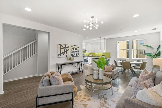 living room with a notable chandelier and dark hardwood / wood-style flooring