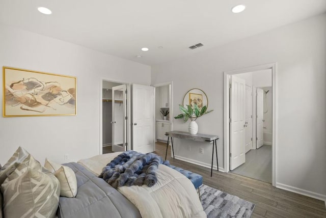 bedroom featuring connected bathroom, a spacious closet, and dark hardwood / wood-style floors