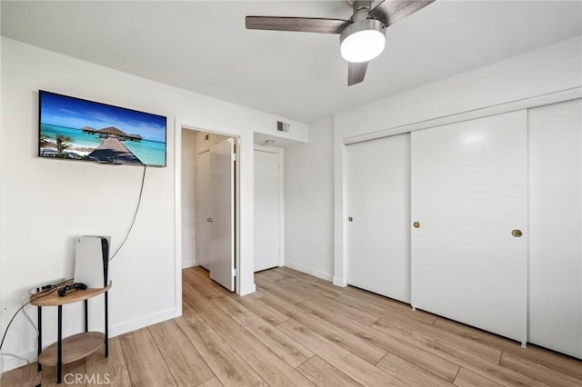 bedroom featuring light hardwood / wood-style flooring, a closet, and ceiling fan