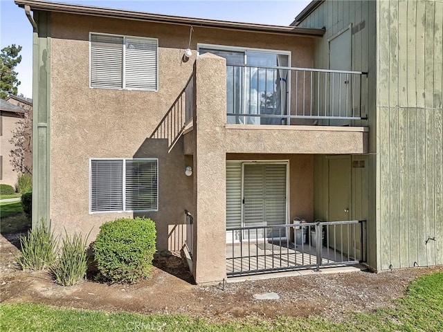 rear view of property featuring a balcony and a patio area