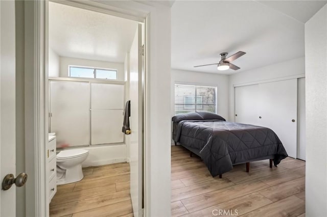 bedroom featuring ceiling fan, a closet, ensuite bathroom, and light hardwood / wood-style flooring