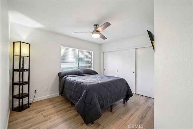 bedroom featuring ceiling fan, a closet, and light hardwood / wood-style flooring