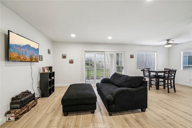 living room with plenty of natural light, light hardwood / wood-style floors, and ceiling fan